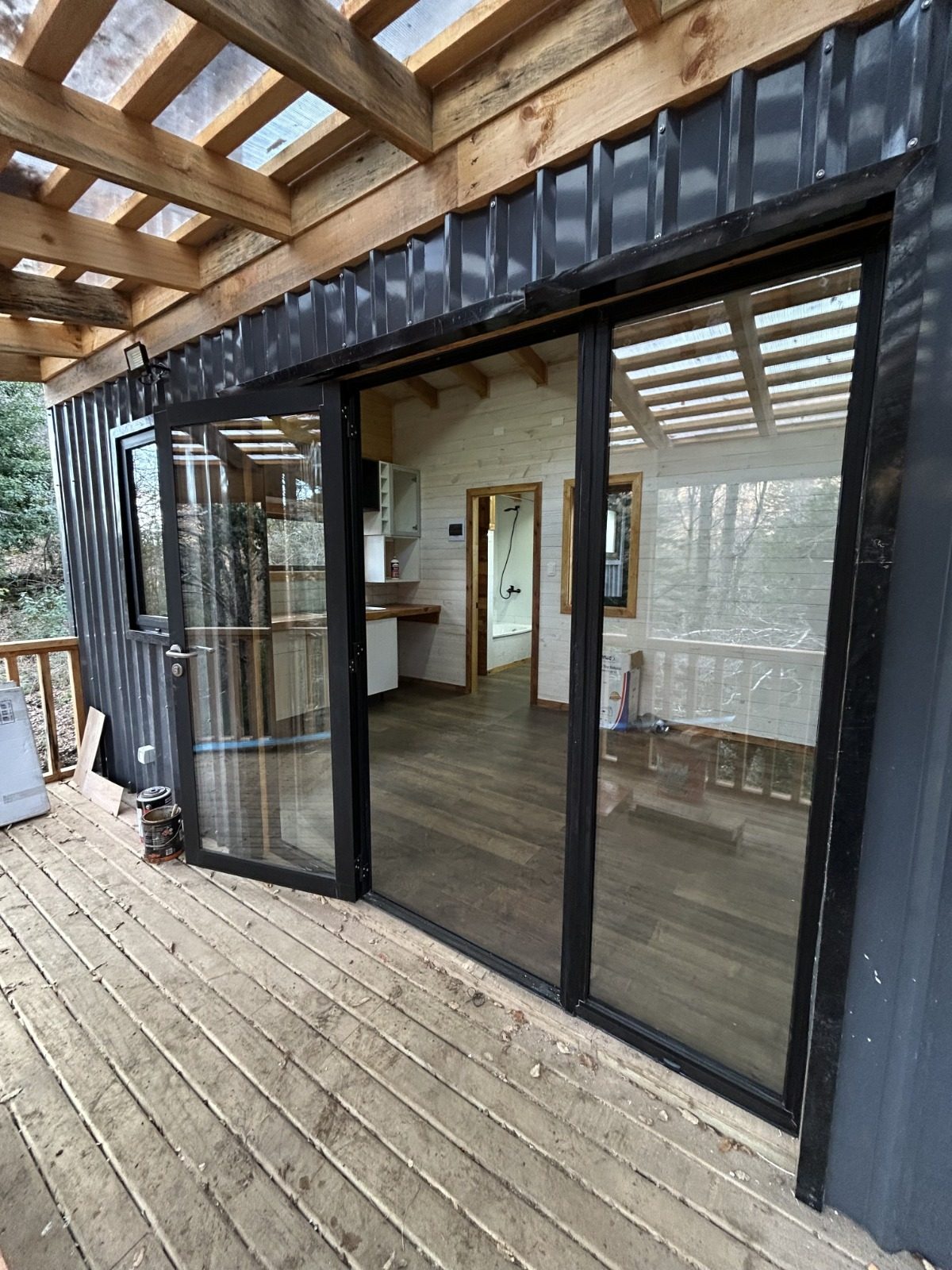 Gran terraza de madera con ventanal corredizo hacia el interior